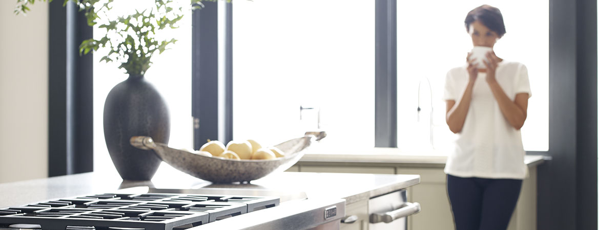 Woman drinking coffee in her Omega kitchen